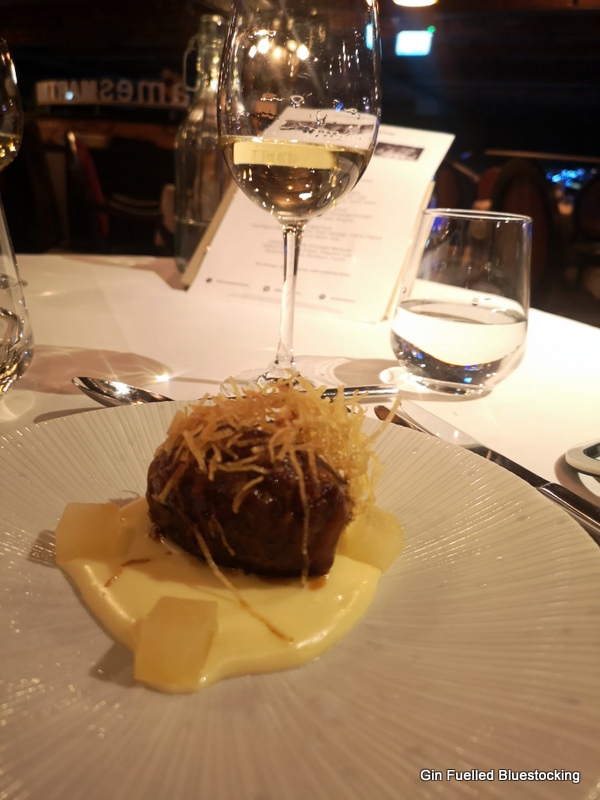 Image: Pork faggot with apple and cider, with the glass of accompanying white wine at James Martin Manchester.