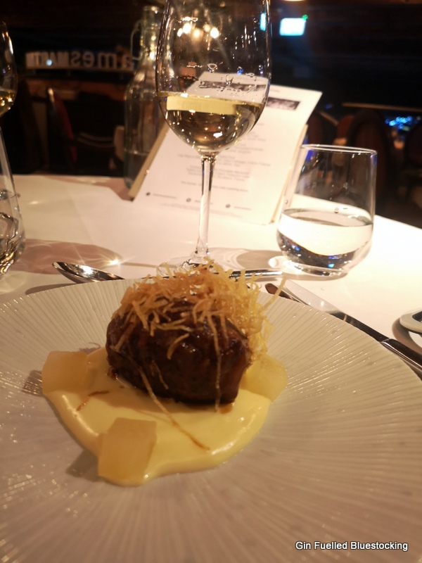 Image: Pork faggot with apple and cider, with the glass of accompanying white wine at James Martin Manchester.