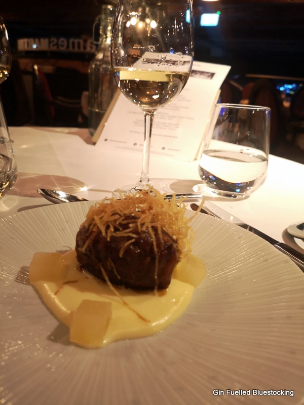 Image: Pork faggot with apple and cider, with the glass of accompanying white wine at James Martin Manchester.
